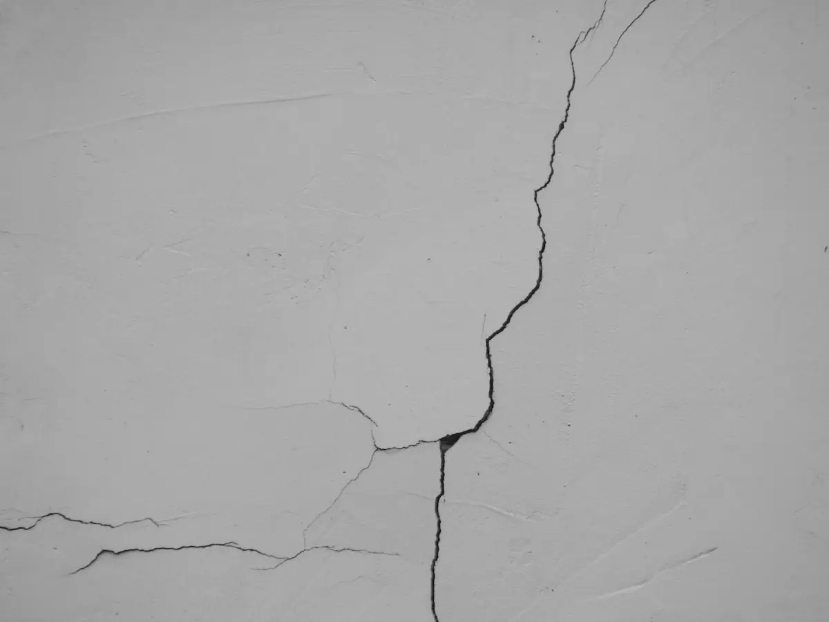 A crack branching down a plastered wall face