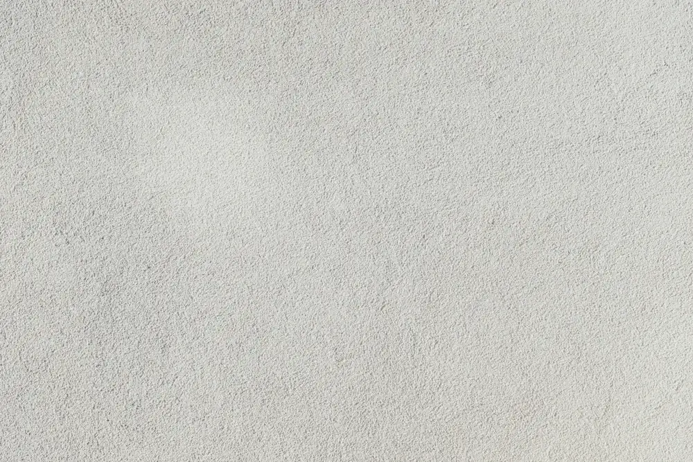 Close-up of a sand-finish stucco surface like the coat applied in block wall stucco work